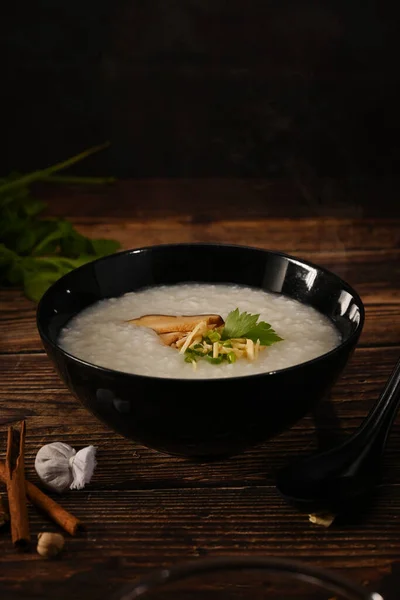 传统的中国粥饭放在碗里 配以软煮熟的鸡蛋 姜片和葱片 便餐及素食 — 图库照片