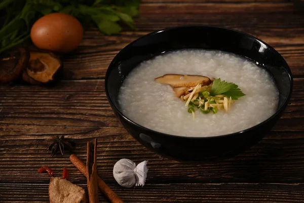 米粥或粥 配软煮熟的鸡蛋 芝麻蘑菇 生姜片和平底锅 — 图库照片