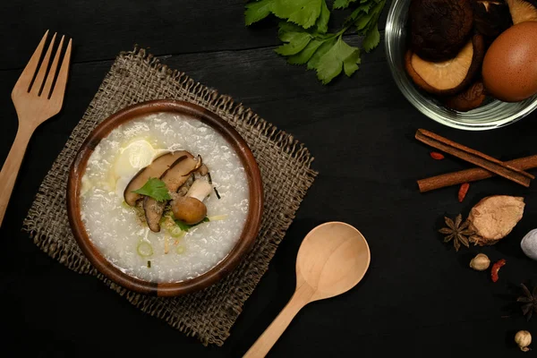 Nutritious rice porridge with soft boiled egg, shiitake mushroom, slice ginger and slice scallion. Breakfast, light meal and vegetarian food.