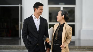 Ofis binasının önünde dururken iki iş ortağının yeni projeyi tartışırken çekilmesi..