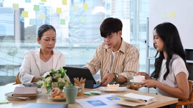 Proje geliştirme, modern ofiste birlikte çalışma konularını tartışan profesyonellerden oluşan bir ekip..