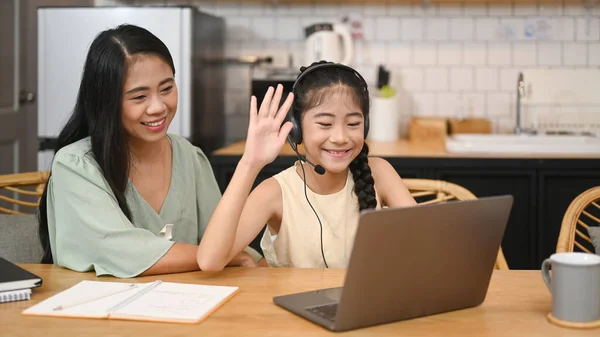 Kulaklıklı Neşeli Asyalı Kız Evde Dizüstü Bilgisayarla Öğretmenle Konuşurken Yanında — Stok fotoğraf