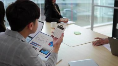 Olgun kadın şirket lideri beyaz tahtanın önünde duruyor ve çeşitli iş adamlarına mali rapor grafiğini açıklıyor.. 