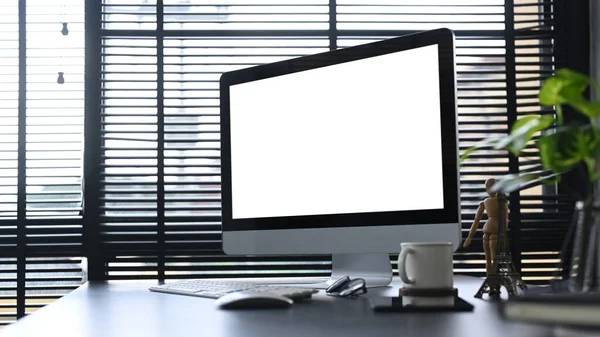 Bilgisayarlı ofis masası, kahve fincanı, paketler ve ev bitkisi. Reklam metniniz için boş ekran.