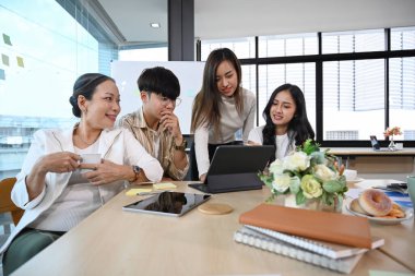 Bir grup başarılı iş adamı modern ofiste yeni proje stratejilerini tartışıyor, beyin fırtınası yapıyorlar..
