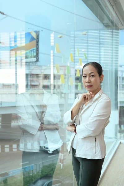 Positiv Verkställande Affärskvinna Står Nära Stora Fönster Kontoret Med Stadsbyggnader — Stockfoto