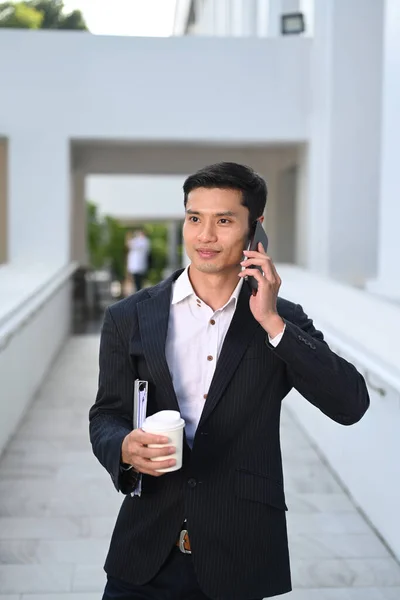Jóképű Férfi Vállalkozó Formális Ruhákban Telefonbeszélgetéssel Sétálva Modern Irodaház Előtt — Stock Fotó