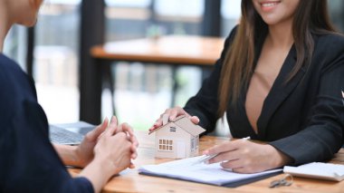 Emlakçı müşteriye gelecekteki emlak alım sözleşmesi şartlarını öneriyor. Gayrimenkul yatırımcıları ve satış sözleşmeleri kavramı.