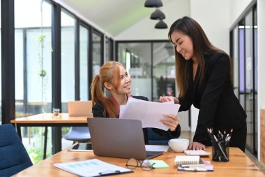 Dost canlısı bayan yönetici tavsiyelerde bulunuyor. Ofisteki genç çalışana proje planını açıkla..