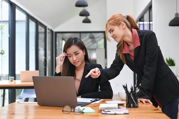 Furious female manager scolding young frustrated intern with bad work results. Emotional pressure, stress at work, verbal warning about work failure.