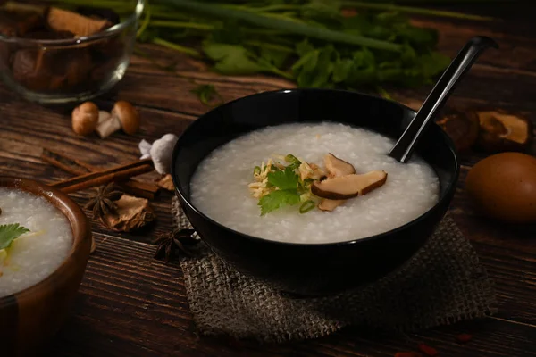 Rice porridge, rice gruel or congee with shiitake mushroom, slice ginger and scallion for breakfast.