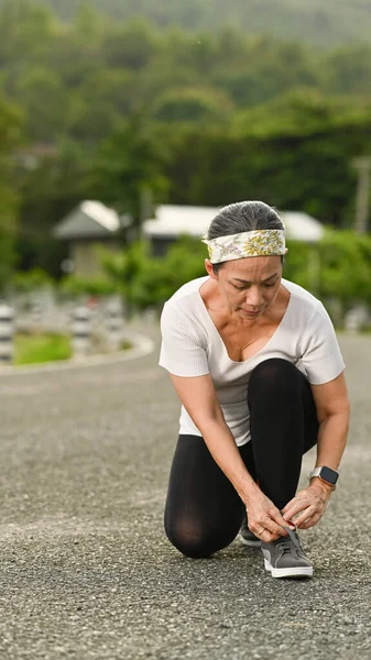 Koşmadan Önce Ayakkabı Bağcığı Bağlayan Orta Yaşlı Bayan Dışarıda Koşuya — Stok fotoğraf