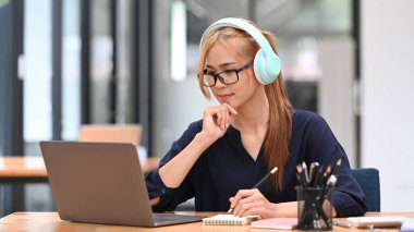 Webinar 'ı izleyen genç bir bayan bilgisayar konferans görüntüleriyle iletişim kuruyor..