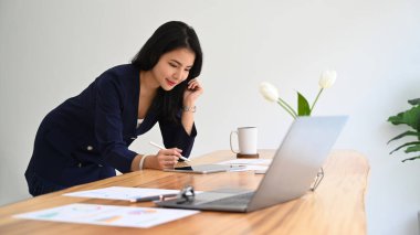 Ofis masasında dijital tablet kullanan profesyonel bir iş kadını..