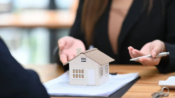 Cropped view of real estate agent offering home ownership and property insurance to costumer.