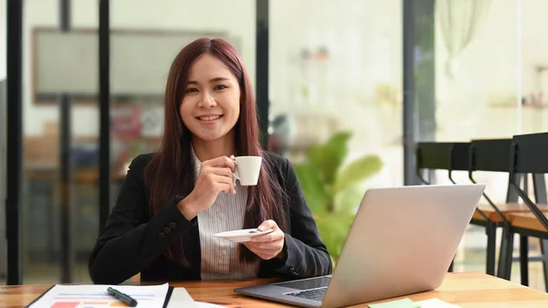 Positivo Jovem Empreendedor Sentado Frente Laptop Com Xícara Café Sorrindo — Fotografia de Stock
