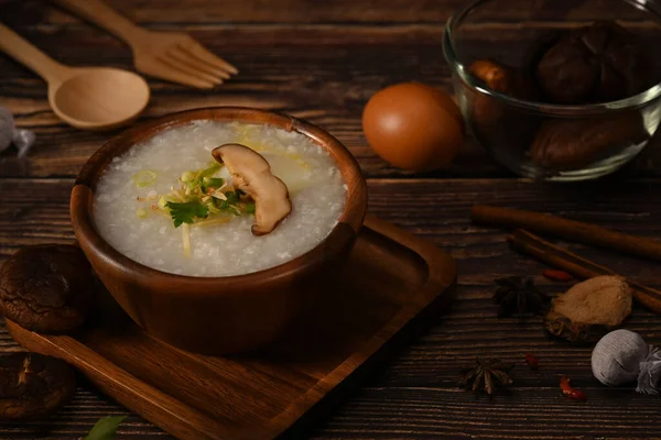 Delicious the traditional Chinese breakfast, rice porridge with soft boiled egg, shiitake mushroom, slice ginger and scallion.