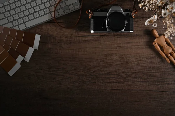 Creative designer workspace with camera, flower pot and color swatches. Top view with copy space.