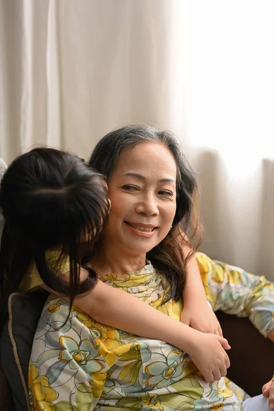小孙女在她祖母的脸颊上拥抱和亲吻 家庭与爱情概念 — 图库照片