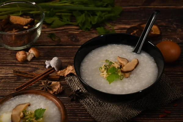 粥或米粥碗 配以蘑菇 生姜和葱片 简单的亚洲早餐放在木桌上 — 图库照片