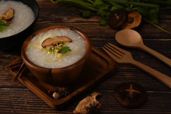 米粥或粥 配上蘑菇 生姜片和葱片 放在木碗里吃便餐 — 图库照片