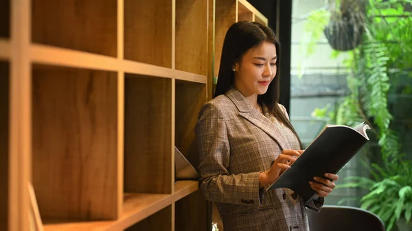 Concentrated Young Businesswoman Standing Bookshelves Bright Company Office — ストック写真