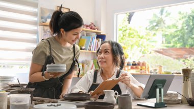 El işi çömlekçiliği sahipleri karton kutuda mal taşıyorlar. Çevrimiçi satış, E-ticaret kavramı.
