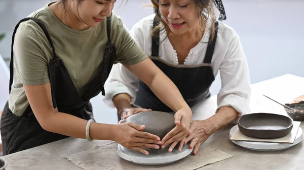 Young Woman Teaching Mature Woman Making Ceramic Pot Clay Pottery — Stockfoto