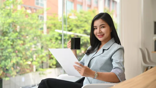 Elegant Young Professional Woman Drinking Coffee Reading Document Bright Modern — 图库照片