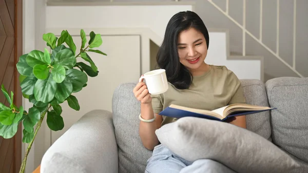 Pretty Young Asian Woman Sitting Couch Reading Interesting Book Enjoying — Stockfoto