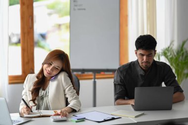 Şirket ofisinde modern cihazlarla çalışan genç iş arkadaşları.