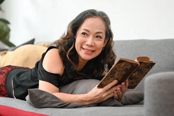 Relaxed Middle Aged Woman Reading Book Couch Home Leisure Activity — 스톡 사진