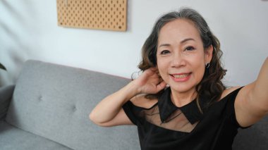 Fotoğraf makinesi tutan, selfie çeken ya da sosyal ağ için haber kaydeden orta yaşlı bir kadın..