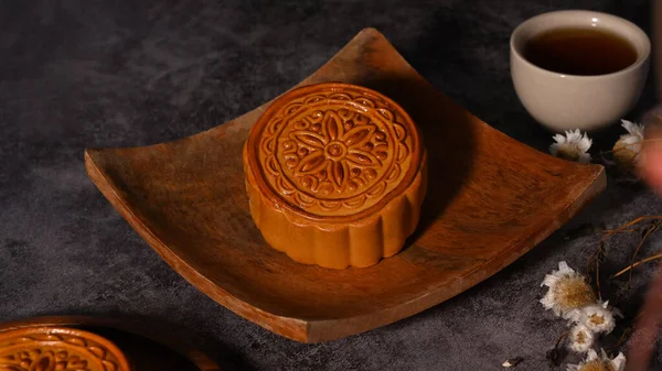 Mid autumn moon cakes and tea on grey rustic background. Concept of Chinese traditional food and dessert.