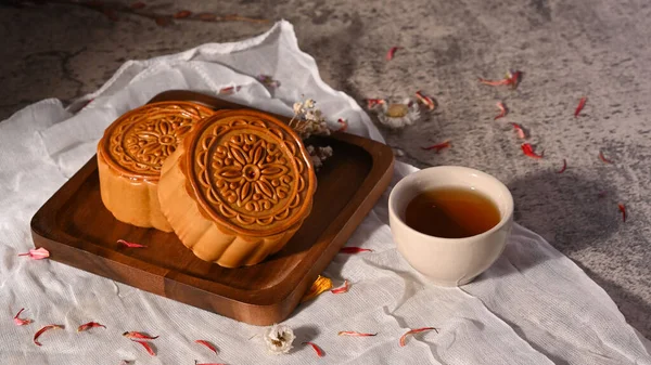 Mid autumn festival mooncake and cup of tea on stone table.