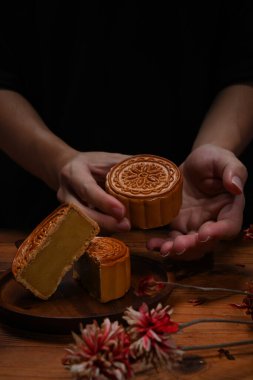 El ele tutuşup Çin usulü ay çöreği yiyelim. Sonbahar ortası festivali ve geleneksel Çin festivali konsepti.