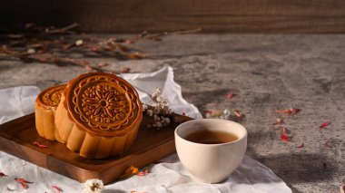Lezzetli geleneksel ay çöreği ve paslı taş masada bir fincan çay. Sonbahar ortası festivali ve Çin geleneksel tatlısı.