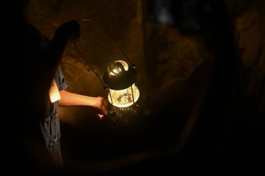 Fenerli kadın gezgin büyük bir mağarayı keşfediyor. Macera, seyahat, turizm ve tatil konsepti.