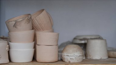 Yaratıcı stüdyonun ahşap rafında el yapımı seramik çanak çömlek..