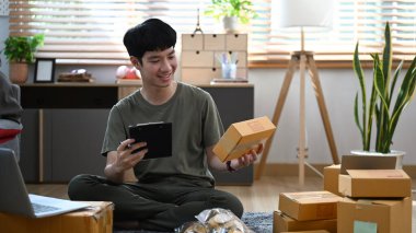 Küçük işletme sahibi kargo için kutu kutu mal hazırlıyor. Ev ofisinde çalışıyor. Çevrimiçi satış, e-ticaret kavramı.