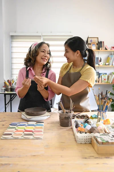 Smiling Mature Woman Potter Helping Young Woman Creating Earthenware Pottery — Stok fotoğraf