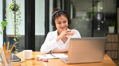 Smiling female freelancer, chatting online, video call conference with her remote team on laptop computer.