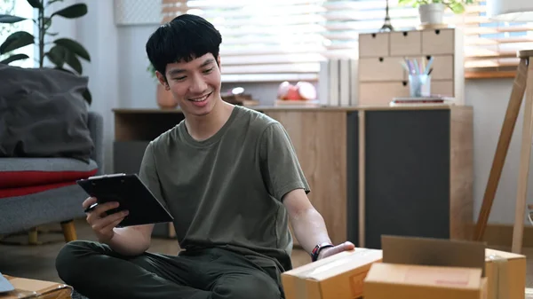 Smiling Asian Male Online Seller Checking Product Purchase Order Preparing — ストック写真
