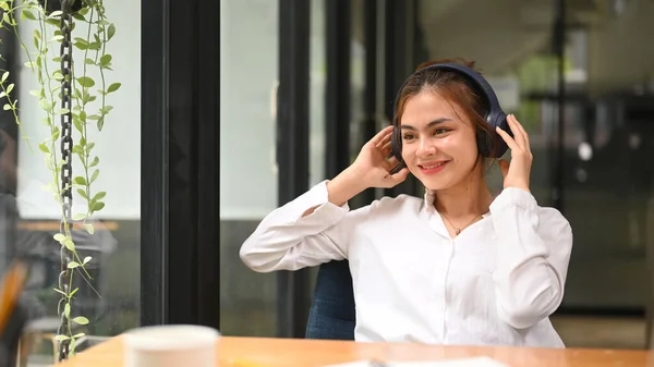 Joyful Young Female Listening Favorite Music Wireless Headphone While Sitting — 스톡 사진