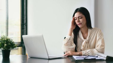 Exhausted business woman working with laptop in the office. Emotional pressure, stress at work concept.