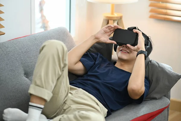 Man Casual Clothes Lying Couch Experiencing Opportunities Gaming Virtual Reality — Stock Fotó