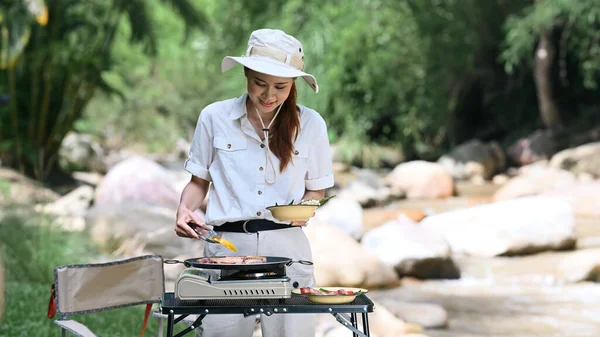Young Woman Grilling Meat Portable Gas Stove While Camping Nature — Stok fotoğraf