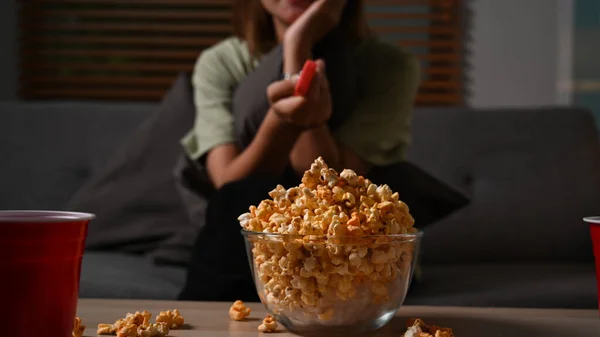 Νεαρή Γυναίκα Τρώει Ποπκόρν Και Βλέπει Τηλεόραση Στον Καναπέ Ψυχαγωγική — Φωτογραφία Αρχείου