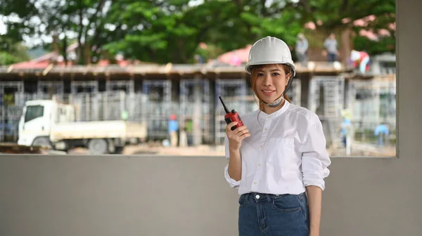 Female civil engineers in safety helmet standing at construction site. Industry, Engineer, construction concept.