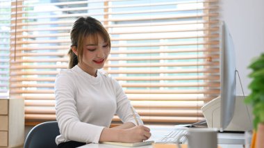 Beautiful young female freelancer working online from home with winter atmosphere.